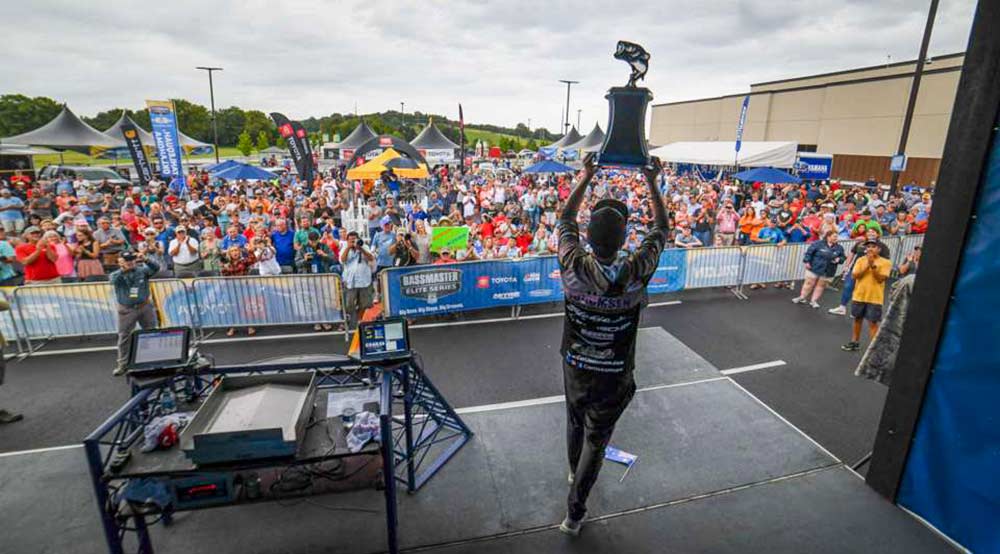 carl jocumsen hoists bassmaster elite trophy at lake tenkiller