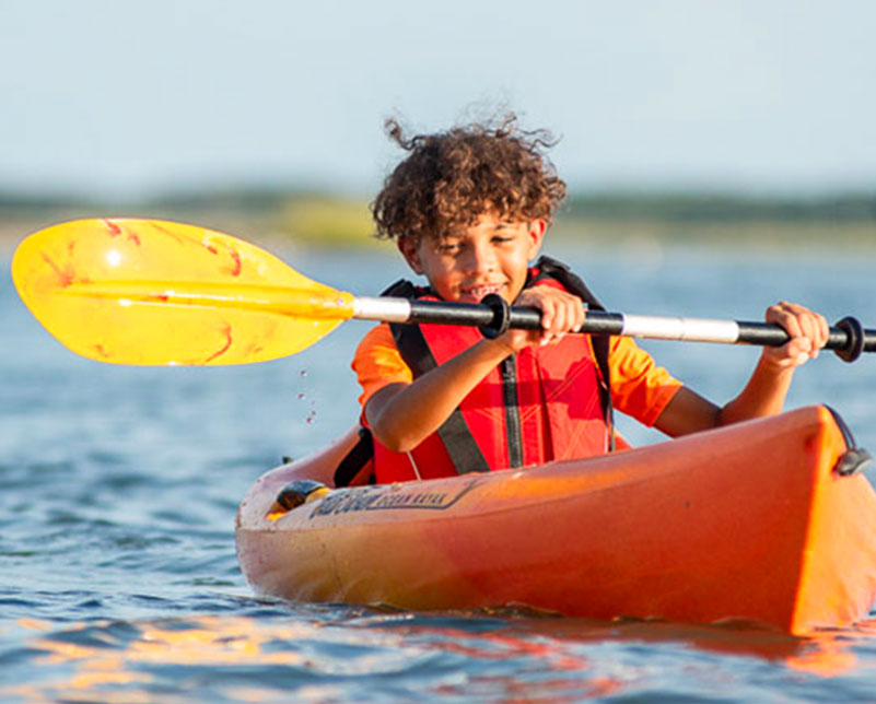 Child paddling with the Saber Kid's paddle