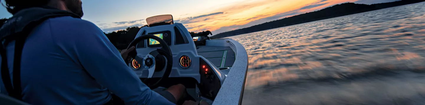 Fishing at sunset on lake in boat with fish finder